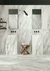 Modern bathroom with marble walls and floor, featuring two sinks and mirrors.